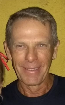 Foto de perfil de um atleta sorrindo, em traje esportivo, transmitindo alegria e entusiasmo pela prática esportiva.