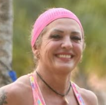 Foto de perfil de um atleta sorrindo, em traje esportivo, transmitindo alegria e entusiasmo pela prática esportiva.